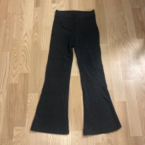 Grå byxor med utsvängda ben - Snygga grå byxor med utsvängda ben och hög midja. Tillverkade i ett mjukt och bekvämt material.