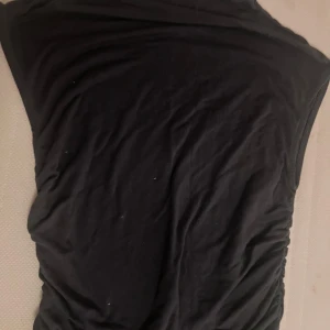 Svart topp från Gina Tricot - Säljer en stilren svart topp från Gina Tricot i storlek M. Perfekt basplagg för garderoben. Den är i färgen mörk grå.