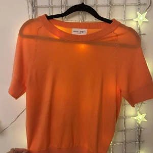 Ljus orange/aprikos färgad tröja från Holly & Whyte - Säljer en snygg orange tröja från Holly & Whyte av Lindex. Tröjan har korta ärmar men ändå lite längre än ”vanliga” T-shirt ärmar. Den är nästintill aldrig använd, max använt 2ggr i somras. Säljer för att den aldrig används. Jätteskönt material har flera likadana fast i andra färger. Passar XS/S