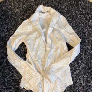 Vit skjorta från Dressmann - Säljer en stilren vit skjorta från Dressmann i slim fit. Skjortan har långa ärmar och knappar framtill. Perfekt för en elegant look.