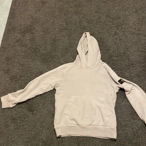 Beige hoodie från Stone Island storlek 152/158 -   Hej! Jag säljer denna Stone Island-hoodie eftersom den tyvärr är för liten för mig. Den är i toppskick (9/10) och har bara använts vid ett fåtal tillfällen, så den känns nästan som ny! Perfekt för dig som letar efter stil och kvalitet i ett plagg.  Skicka gärna ett meddelande om du har frågor eller vill slå till! 