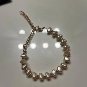 Pärlarmband med justerbar kedja - Elegant armband med vita pärlor och en justerbar kedja. Aldrig använt. 