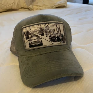 Emilio Pendenza Suede keps - Snygg grå keps med ett unikt tryck framtill. Kepsen har ett nätmaterial på sidorna och baksidan för extra ventilation. DM vid frågor. Pris kan diskuteras