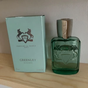 Parfums De Marley Greenley - Greenley Eau de Parfum från Parfums de Marly kommer i en elegant grön flaska med en silverfärgad kork. Flaskan har en stilren design med två hästar och ett emblem ingraverat. Förpackningen är i matchande grön nyans. Mängd enligt bild ca 62 kanske. Skriv vid minsta fundering eller för en bättre bild för mängden. Priset är diskuterbart 