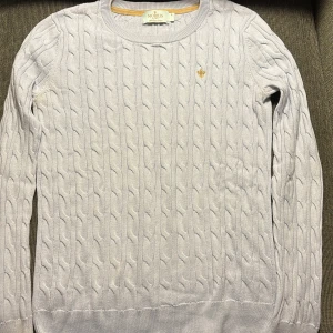 Vit kabelstickad tröja från Morris - Säljer en stilren vit kabelstickad tröja från Morris Lady i 100% pima bomull. Tröjan har en rund halsringning och ett diskret broderat emblem på bröstet. Använt många gånger. OBS! Har hund i hemmet men hon fäller INTE päls!