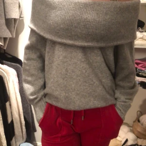 Grå offshoulder tröja - Säljer en mysig grå offshoulder tröja med ribbad kant. Perfekt för en stilren och avslappnad look. Tröjan har en lös passform och långa ärmar.