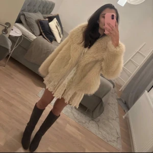 Beige pälsjacka - Säljer en fluffig och stilren beige pälsjacka med lång ärm. 
