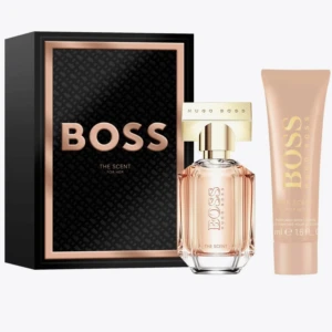 BOSS The Scent for Her presentset - Elegant presentset med BOSS The Scent for Her. Innehåller en parfymflaska med en lyxig, feminin doft och en matchande body lotion. Flaskan har en stilren design med guldlock och transparent glas. Perfekt för den som vill ha en sofistikerad och förförisk doftupplevelse.