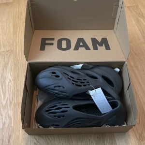 Svarta Yeezy Foam Runners - Säljer ett par svarta Foam Runners som var för små. (Kvitto finns) Perfekta för en avslappnad stil och bekväma att bära hela dagen.