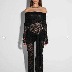 Svart spetsklänning  - Trendig svart offshoulder klänning i spets med långa ärmar. Den har en elegant omlott-detalj framtill och en figurnära passform. Perfekt för en stilfull kväll. Ett M men känns som ett SHelt ny med tag och allt. Ord. pris 850kr pris kan diskuteras 