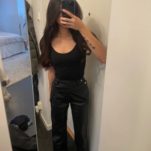 Svarta skinnbyxor från A-dsgn - Snygga svarta skinnbyxor med hög midja och raka ben. Byxorna är från A-dsgn och är i storlek Xxs, har även sytt upp byxorna så att de passar en som är runt 164 cm.