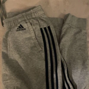 Grå adidas byxa - Grå adidas byxa med marinblåa streck, stl S dam. Bra skick. Hör av er vid frågor eller för fler bilder.