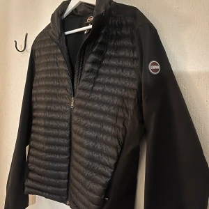 Svart Vindjacka/Cardigan från Colmar - Snygg svart quiltad vinter/vår jacka från Colmar med dragkedja och långärmade ärmar. Perfekt för kyligare dagar med sin stilrena design och bekväma passform. Storlek S, passar för dig som är mellan 170-185. Hör av dig för frågor!