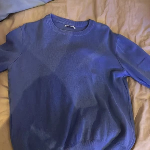 Blå tröja från Zara - Säljer en stilren blå tröja från Zara. Tröjan har en klassisk rund halsringning och långa ärmar. Perfekt för en avslappnad look.