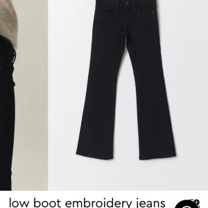 Svarta bootcut jeans med broderi - Snygga svarta bootcut jeans med subtilt broderi. Perfekta för en stilren look med en twist. De har en låg midja och klassisk femficksdesign.