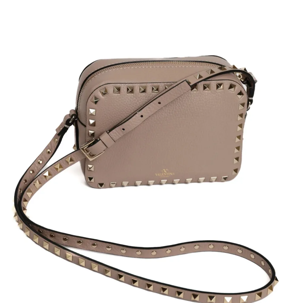 Snygg beige axelväska från Valentino med guldfärgade nitar runt kanterna. Väskan har en justerbar axelrem och är perfekt för att ge en edgy touch till din outfit. Väskan är äkta då de går att kolla upp. Köpte av en tjej på Plick där äktighets bevis fanns! Ser ut som ny och har inga defekter💗. Laukut & Käsilaukut.