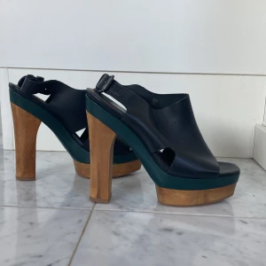 Klackskor med träklack  - Coola platå-klackskor i 100% läder och med trä klack plus mörkgröna detaljer. Perfekt att ha på sommaren till ett par jeans typ😍