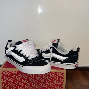 Vans Knu Skool Black/True White - Säljer ett par Vans Knu Skool i svart och vitt. Skorna har klassisk snörning och den ikoniska 'Off the Wall'-loggan på hälen. Perfekta för en avslappnad stil. Skorna har ett litet jack på hällen som man knappt märker. Jag har användt dom runt 2-3 gånger. Kommer med låda 