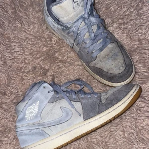 Grå Nike Air Jordans - Snygga grå Nike Air Jordans med en stilren design. Skorna har en kombination av mocka och syntetmaterial med snörning och en gummisula i kontrasterande färg. Liten defekt inne i skorna men inga andra problem!!!