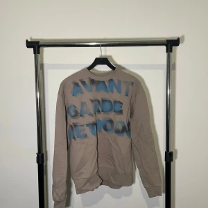 Beige sweatshirt från Zara - Säljer en beige sweatshirt från Zara med texten 'AVANT GARDE METHOD' i blått på framsidan. Tröjan har långa ärmar och en rund halsringning. Perfekt för en avslappnad stil.