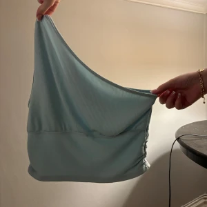 Ljusblå oneshoulder topp - Snygg ljusblå oneshoulder topp med ribbad textur. Perfekt för en stilren look med en unik asymmetrisk design.