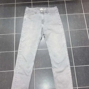 Grå jeansbyxor - Snygga grå jeansbyxor med en klassisk design. De har en dragkedja och knapp framtill samt fickor både fram och bak. Perfekta för en stilren look.