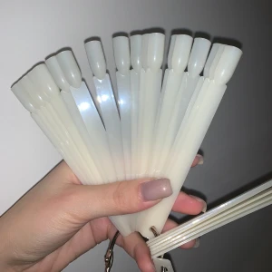 Nagelprovsstickor på nyckelring - Säljer ett set med vita nagelprovsstickor fästa på en metallring. Perfekt för att testa olika nagellack och designa egna mönster. Stickorna är av plast.