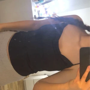 Svart draperad linnetopp från BikBok - Snygg svart linnetopp från BikBok med smala axelband och en draperad halsringning. 