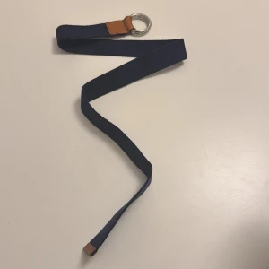 Mörkblå GANT bälte med cirkelspänne - Snyggt och stilrent bälte som passar till linnebyxor och jeans. Nypris: 799kr har inte använt så jättemycket pågrund av att jag växte ur dem. Det är barnstorlek så passar XS. 