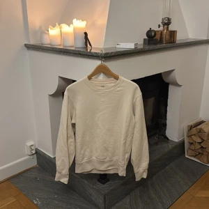 Beige sweatshirt från Uniqlo - Säljer en stilren beige sweatshirt från Uniqlo i storlek XS. Tröjan har en klassisk rund hals och långa ärmar, perfekt för en avslappnad look. Den är tillverkad i ett mjukt material som ger en skön känsla. Passar bra till både jeans och mjukisbyxor. Nypris: 500kr. använt försiktigt och har inga fel alls, skriv vid funderingar!