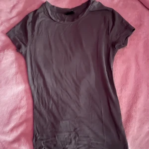 Mörkgrå t-shirt - Snygg mörkgrå t-shirt med korta ärmar. Från gina tricot, sitter tajt och formar kroppen fint. Stl XS