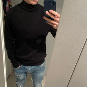 Svart polotröja från Bläck - Säljer en stilren svart polotröja från Bläck. Tröjan har långa ärmar och en klassisk polokrage, perfekt för kyligare dagar. Passar bra till både jeans och mer uppklädda tillfällen.