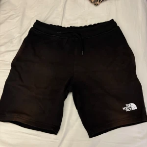 Svarta shorts från The North Face - Snygga svarta shorts från The North Face med logga på benet. De har en bekväm passform med snörning i midjan. Perfekta för en avslappnad stil.