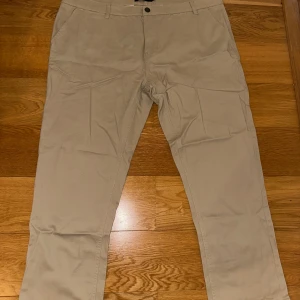 Beige byxor från Marine - Snygga beige byxor från Marine i storlek XXL. Byxorna har en klassisk design med knappar i midjan och är perfekta för en stilren look. Tillverkade i ett bekvämt material som passar bra till vardags.