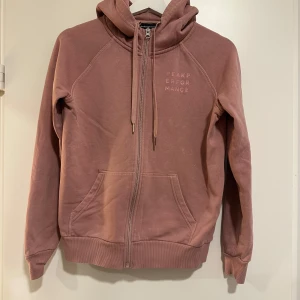 Rosa hoodie från Peak Performance - Säljer en bekväm ”dusty” rosa hoodie från Peak Performance. Storlek S. Den är i bra skick, man kan se skymten av små vita ”fläckar” under loggan men det kan också vara så tyget ska vara, syns knappt i verkligheten. 