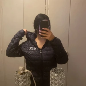 EA7 jacka - En tunn dunnjacka. Perfekt för våren/hösten. Strl L men passar mig som bär s då jag ville ha den lite oversized..