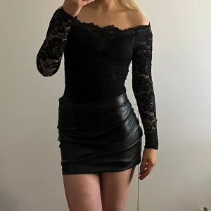 Svart spetsbody från Nelly - Snygg svart offshoulder spetsbody från NLY One. Den är i fint skick, endast använd någon enstaka gång.