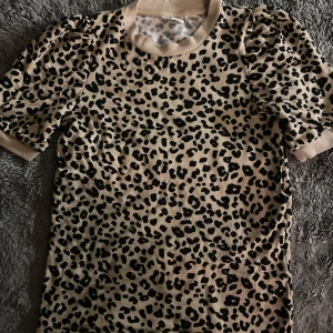 Leopardmönstrad tröja från Lindex - Säljer en jätte fin leopardmönstrad tröja från Lindex i beige och svart. Toppen har korta ärmar och ribbade kanter vid hals och ärmslut. Passar mig perfekt som har storlek S. 🐆✨