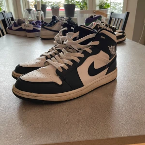 Nike Air Jordans i navy och vit - Snygga Nike Air Jordans i navy och vit med klassisk snörning. Perfekta för dig som älskar stilrena sneakers med ikonisk design.