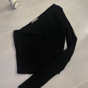 Svart oneshoulder topp - Snygg svart oneshoulder topp med lång ärm. 