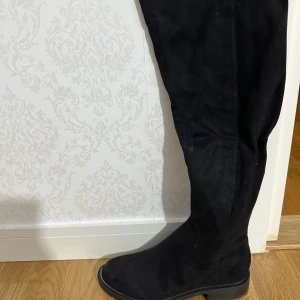 Svarta stövlar med dragkedja - Snygga svarta stövlar i mocka med dragkedja på sidan. Perfekta för höst och vinter med en stilren design som passar till många outfits.