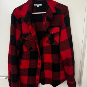 Röd och svart rutig skjorta strl S  - Snygg röd och svart rutig skjorta från Cafébleu med långa ärmar och knappar framtill. Perfekt för en avslappnad stil med två bröstfickor för extra funktionalitet.