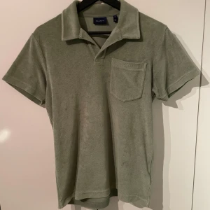 Grön frotté t-shirt från GANT - Snygg grön t-shirt från GANT i frotté med krage och bröstficka. Grymt skick 😀