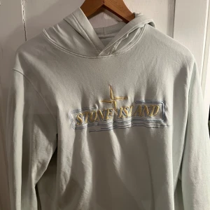Stone Island hoodie - Säljer en snygg hoodie från Stone Island.Hoodien är bara använd några gånger senast 1 år sedan och det är därför den ser lite skyrnklig ut men det fixas innan frakt.Junior storleken är bara en size men den passar allt i mellan 160-180.Priset går att pröjsas.