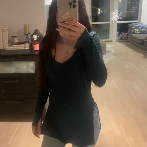 Mörkgrön ribbad tröja från hm - Snygg mörkgrön ribbad tröja från hm med v-ringning. Tröjan har långa ärmar och en figurnära passform som passar perfekt till både jeans och kjol. Perfekt för höst och vinter!