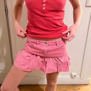 Rosa kortkjol med volang - Lågmidjade volang kjol i jeans