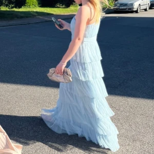 Ljusblå långklänning med volanger - Elegant och väldigt eftertraktad ljusblå långklänning med volanger och en oneshulder design. Perfekt för speciella tillfällen såsom bal. Stlk 36. Klänningen är perfekt för mig som är 162 cm lång!💙💙💙