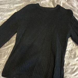 Svart stickad tröja från NA-KD - Säljer en stilren svart stickad tröja från NA-KD i storlek XXS. Tröjan har en klassisk design med långa ärmar och rund halsringning. Perfekt för kyligare dagar och enkel att matcha med olika outfits. 🖤