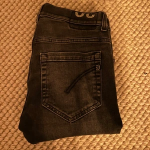 Grå jeans från Dondup - Snygga svarta jeans från Dondup i modellen George. De har en klassisk femficksdesign och en dragkedja i gylfen. Perfekta för en stilren look. Hör av er vid minsta lilla fundering.