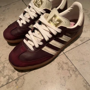 Adidas Sambas vinrött  - Snygga Adidas Samba sneakers i vinrött och vitt, andvänd fåtal gånger, storlek 40 men passar 39-39,5